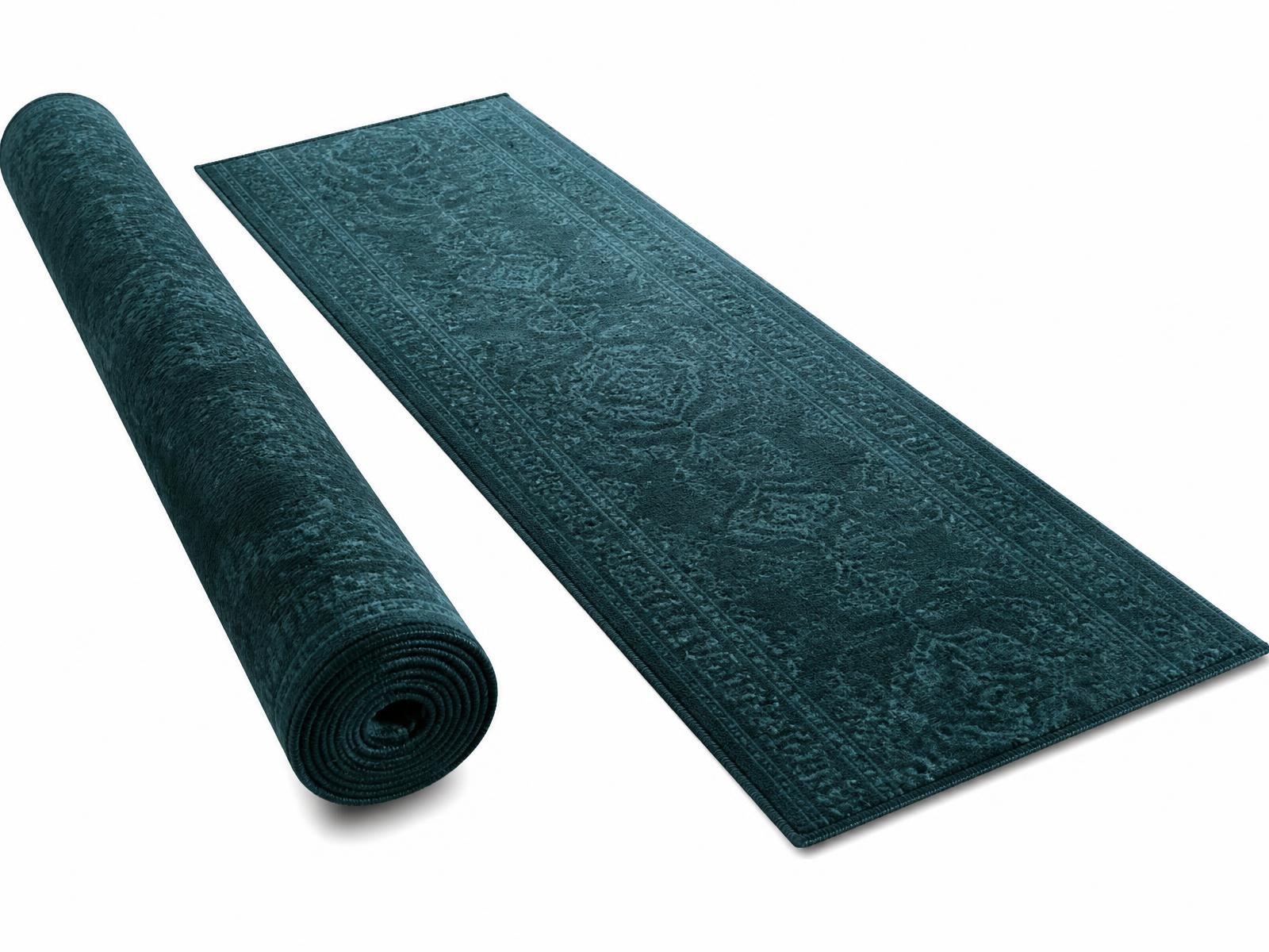 Deep teal luxury runner rug, one rolled and one flat, on a white studio background
